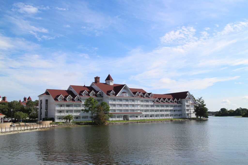 A white hotel building with a dark red roof on a sunny day