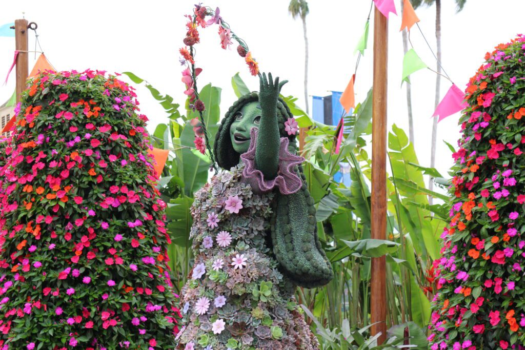 Disney character topiary of Isabela from Encanto using pink and purple succulents.