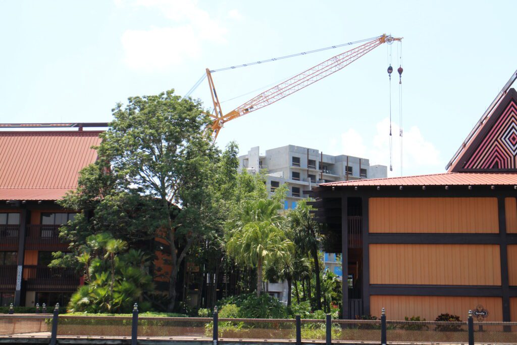 Polynesian resort buildings with a crane and the Polynesian DVC tower under construction in the background