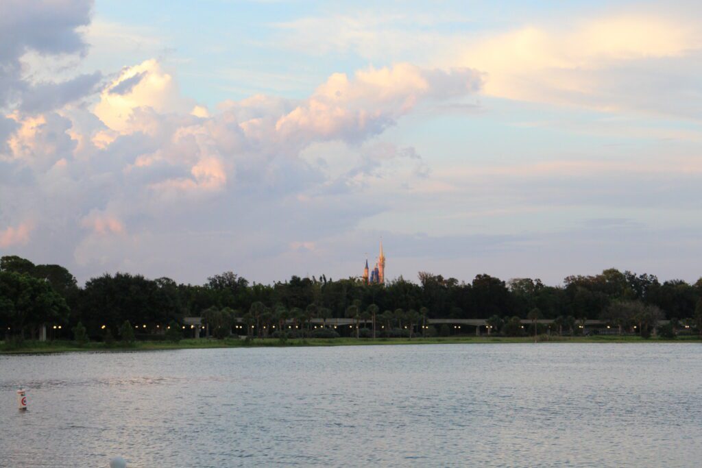 a lake with trees off in the distance and the top of a castle