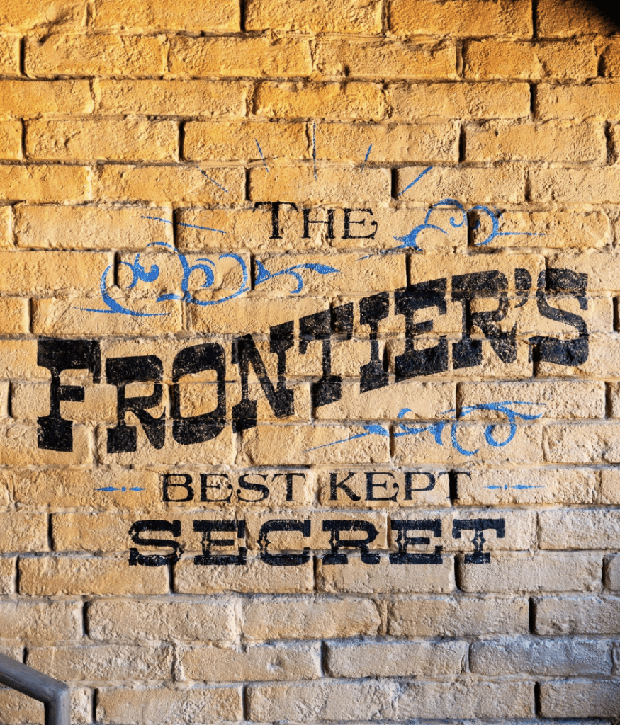 Frontierland DVC Lounge mural that says: "The Frontier's Best Kept Secret" at McKim’s Mile House – A Member Lounge at Magic Kingdom Park