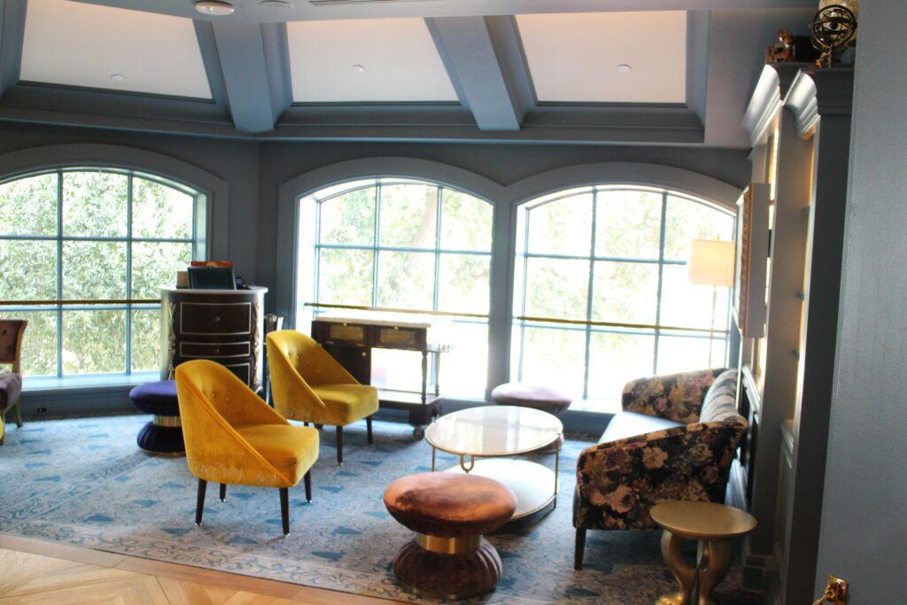 A blueish gray toned room with big windows and stylish furniture, inside Enchanted Rose