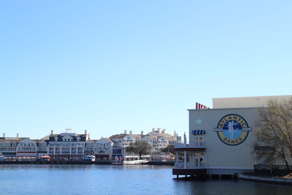 A sparkling, dark lake in front of Disney's BoardWalk resort buildings and the Atlantic Dance Hall venue.