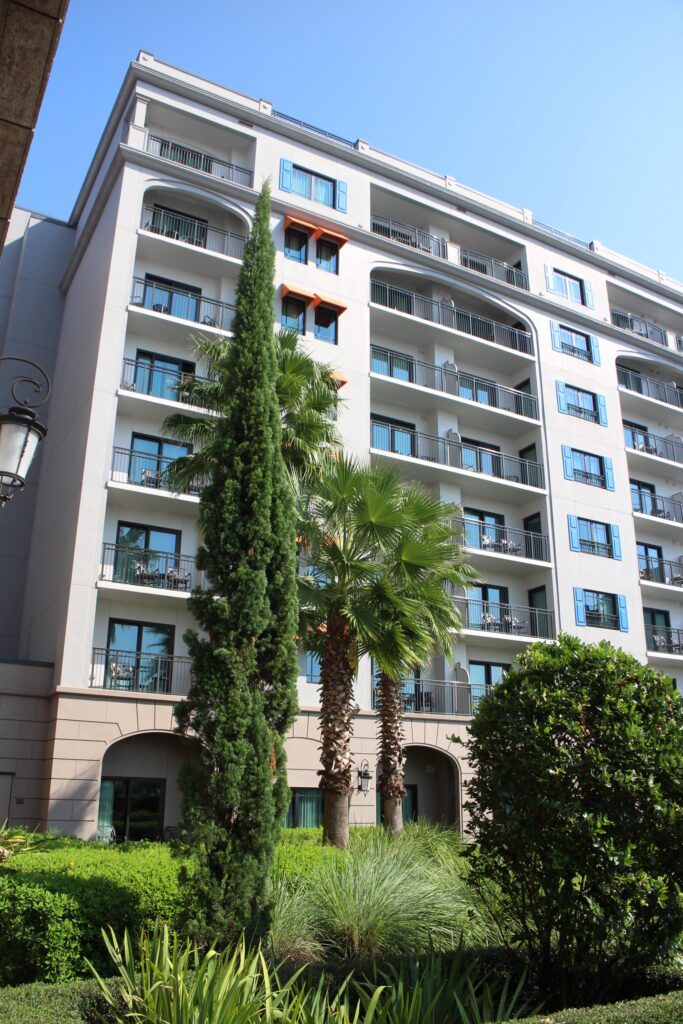 Disney's Riviera Resort exterior and evergreen landscaping.