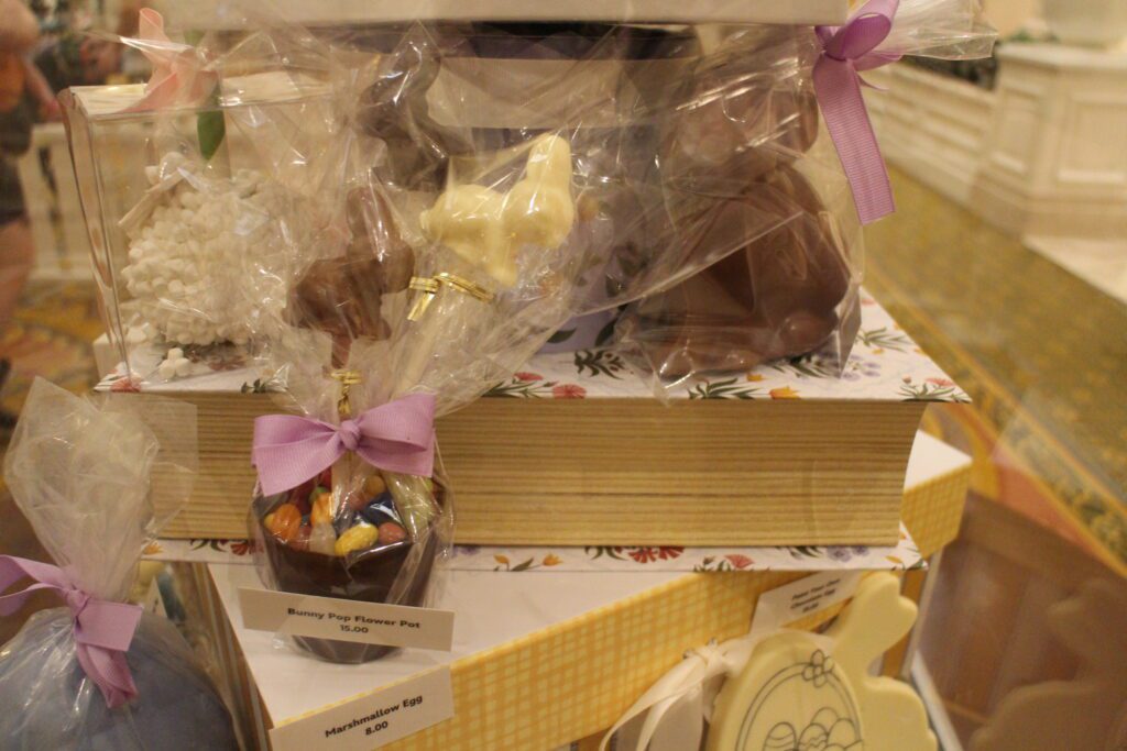 A Grand Floridian Bunny Pop Flower Pot on a display table. It is a small cup with jellybeans on top, wrapped in cellophane with a bow on it.
