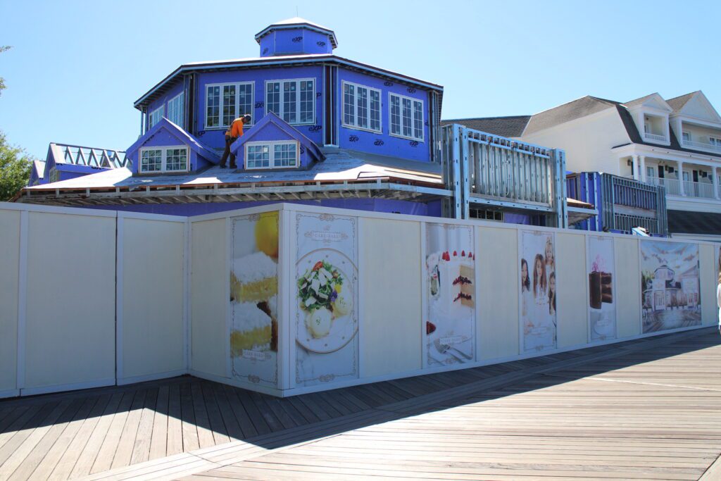 A construction wall surrounds The Cake Bake Shop building on the Disney BoardWalk.