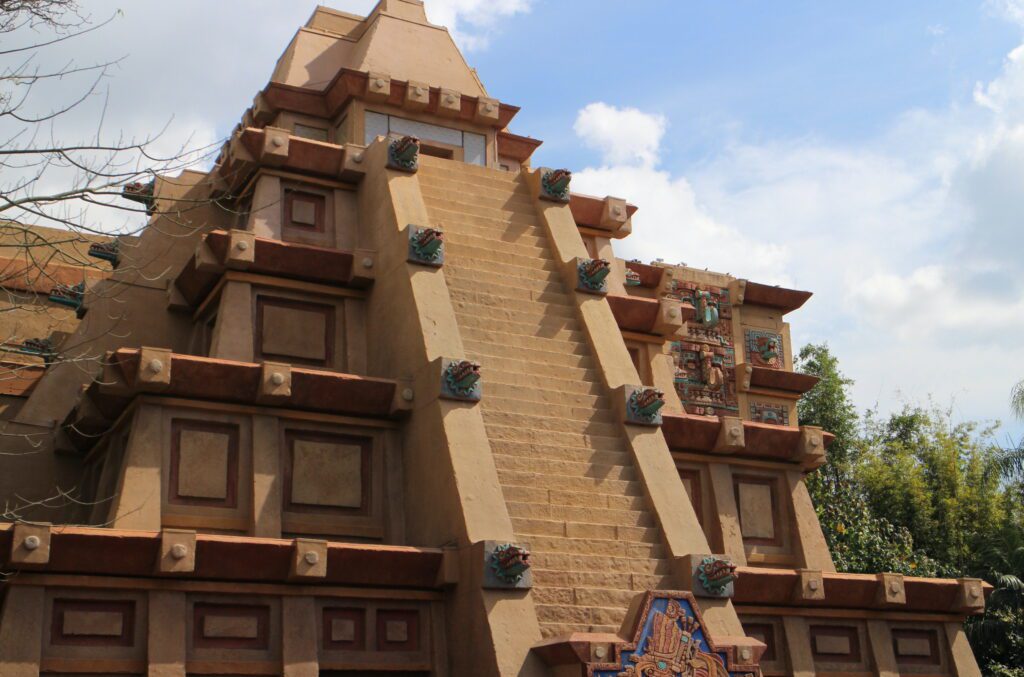 A tall pyramid with stairs on the front in the Mexico pavilion in Disney World. Inside there is a bar, shop, attraction and more.