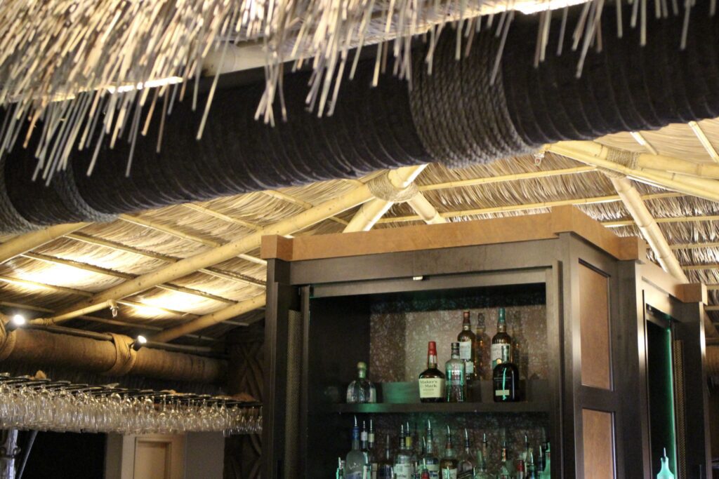 A straw style roof hangs over the themed bar at Tambu Lounge at the Polynesian at Walt Disney World Resort.