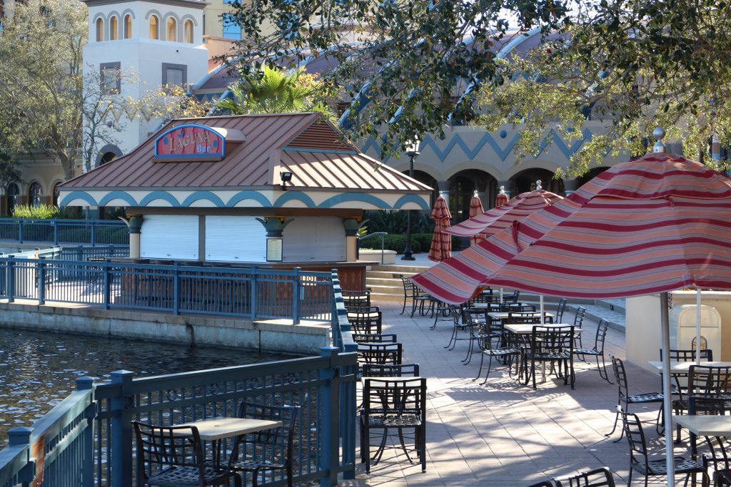 Outdoor seating and a walk up bar surrounded by trees at Coronado Springs.