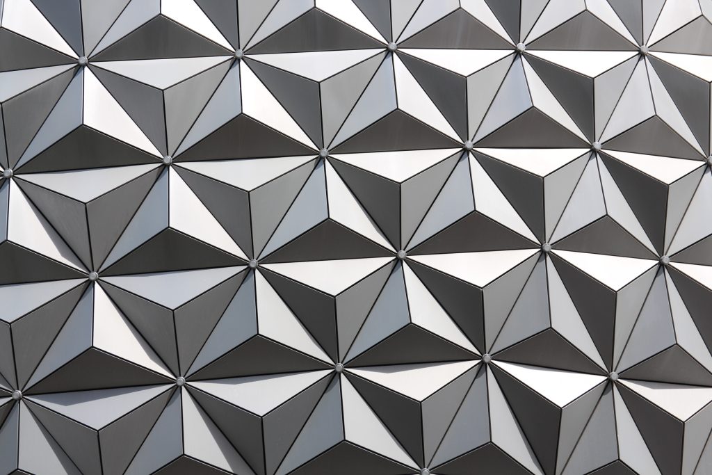A close up of the Spaceship Earth Epcot icon with a silver triangle pattern on the exterior.