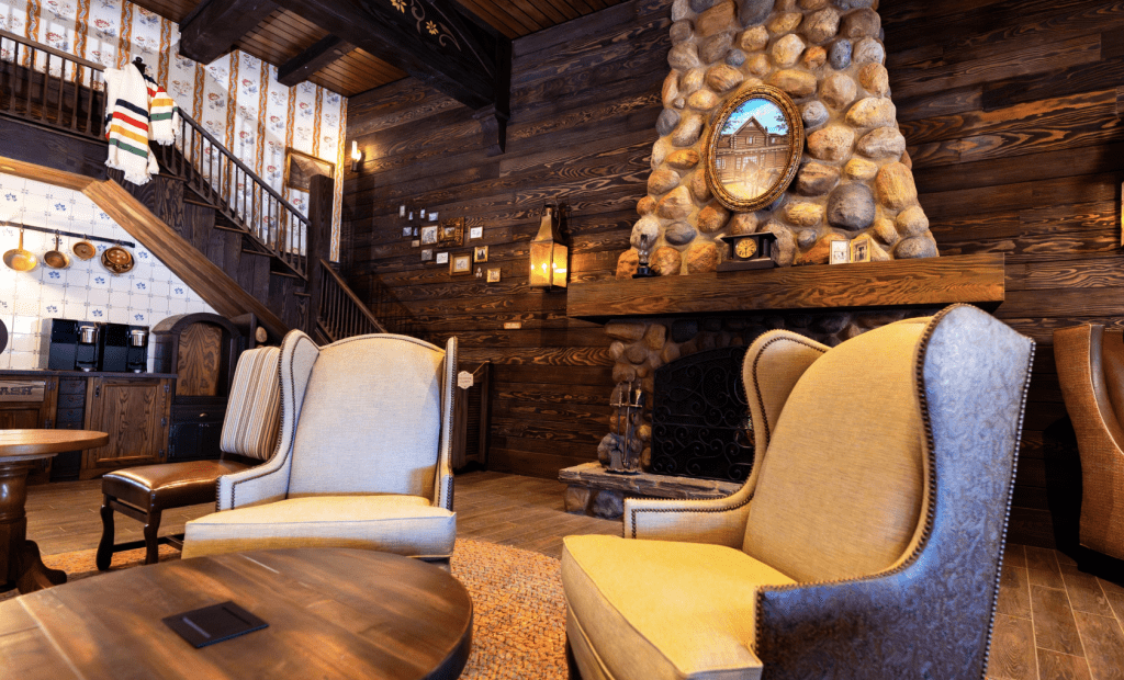 Inside the Magic Kingdom DVC lounge, two western looking wingback chairs sit near a large stone fireplace.