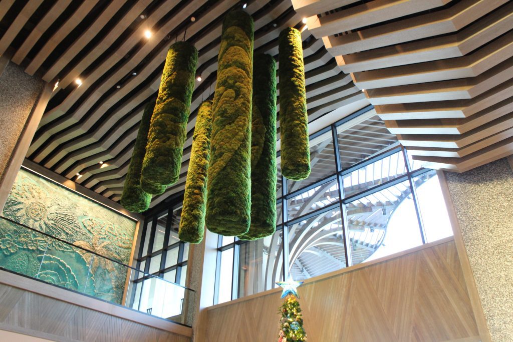 A look at the lobby ceiling in the Polynesian's Island Tower with natural colors including green, moss colored cylinders hanging from the ceiling.