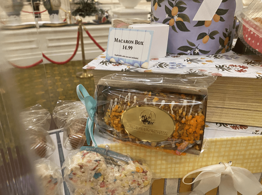 A Cream Cheese Carrot Coffee Cake for $9.49 in a rectangular box with a blue bow and a gold Grand Floridian sticker on it.
