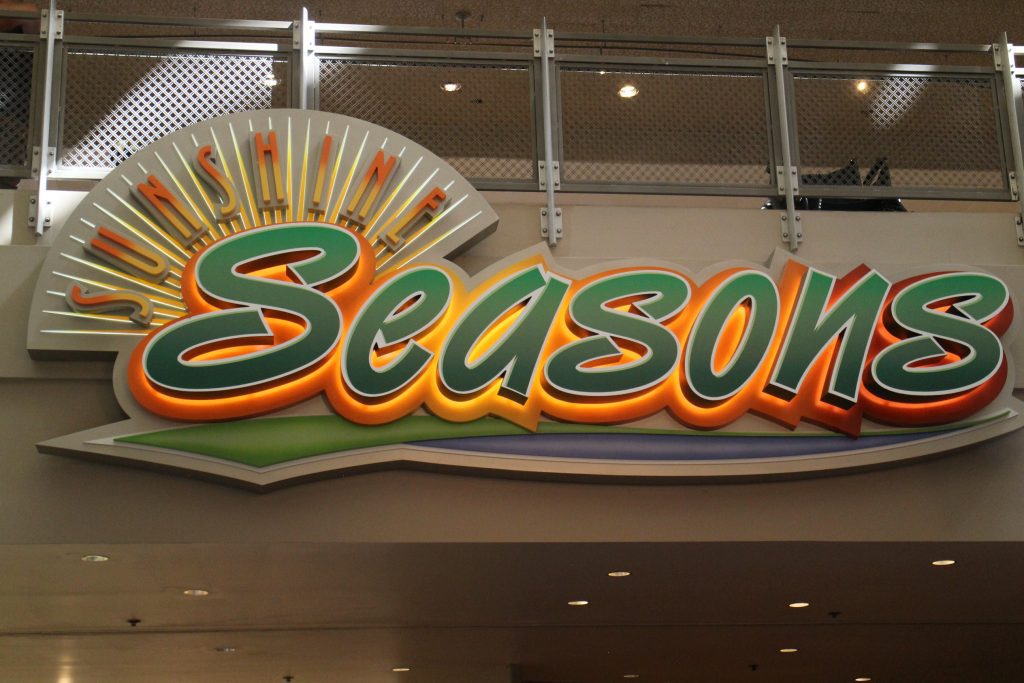 Sunshine Seasons sign at Epcot with what looks like the sun's rays.