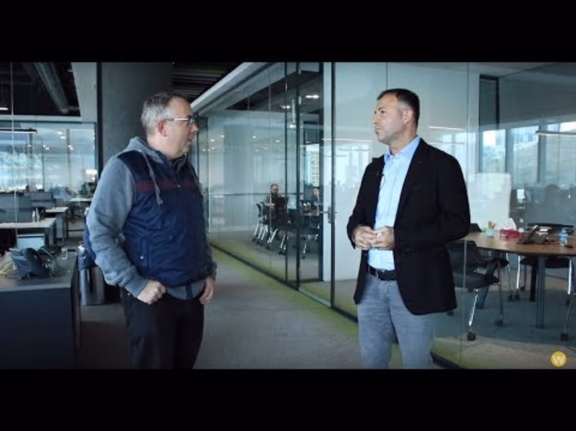 Two colleagues talking during a tour of the Sestek office