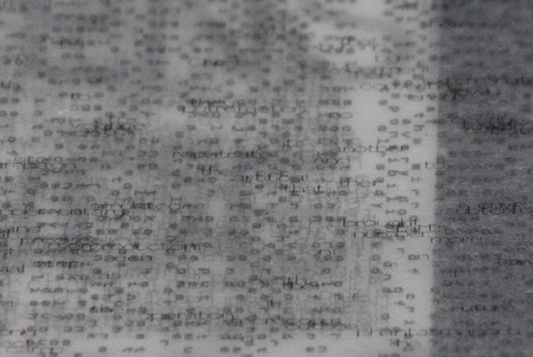 Macro shot of the premium book, showcasing the tiny typography that acts as a texture element in the design.