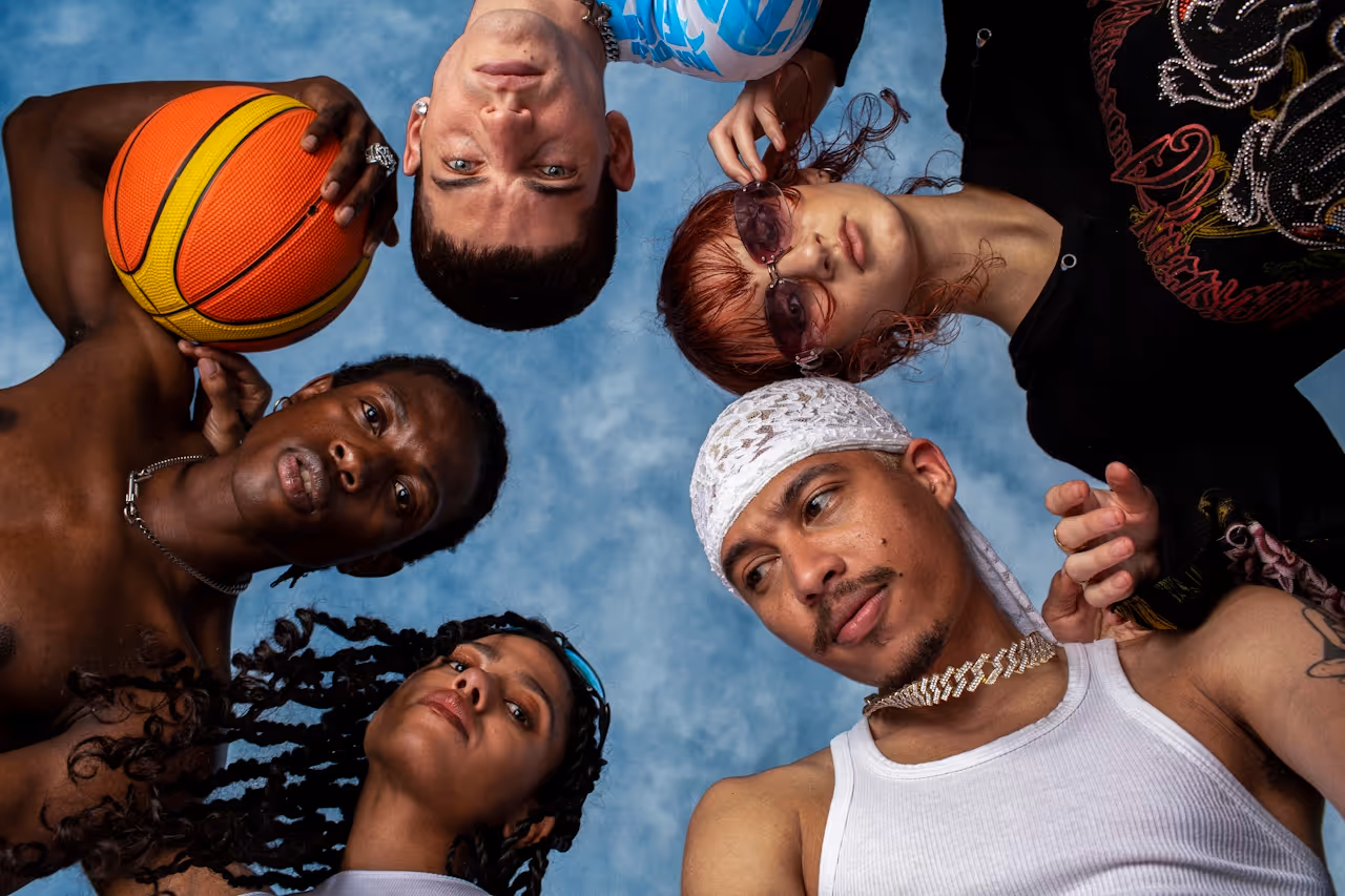 Franco Dupuy worm's eye view photograph of a group of young adults with a basketball looking down into the camera.