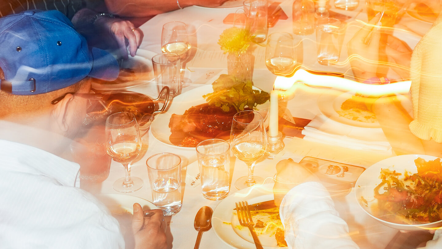 blurred photo of people at large dining table eating thai food