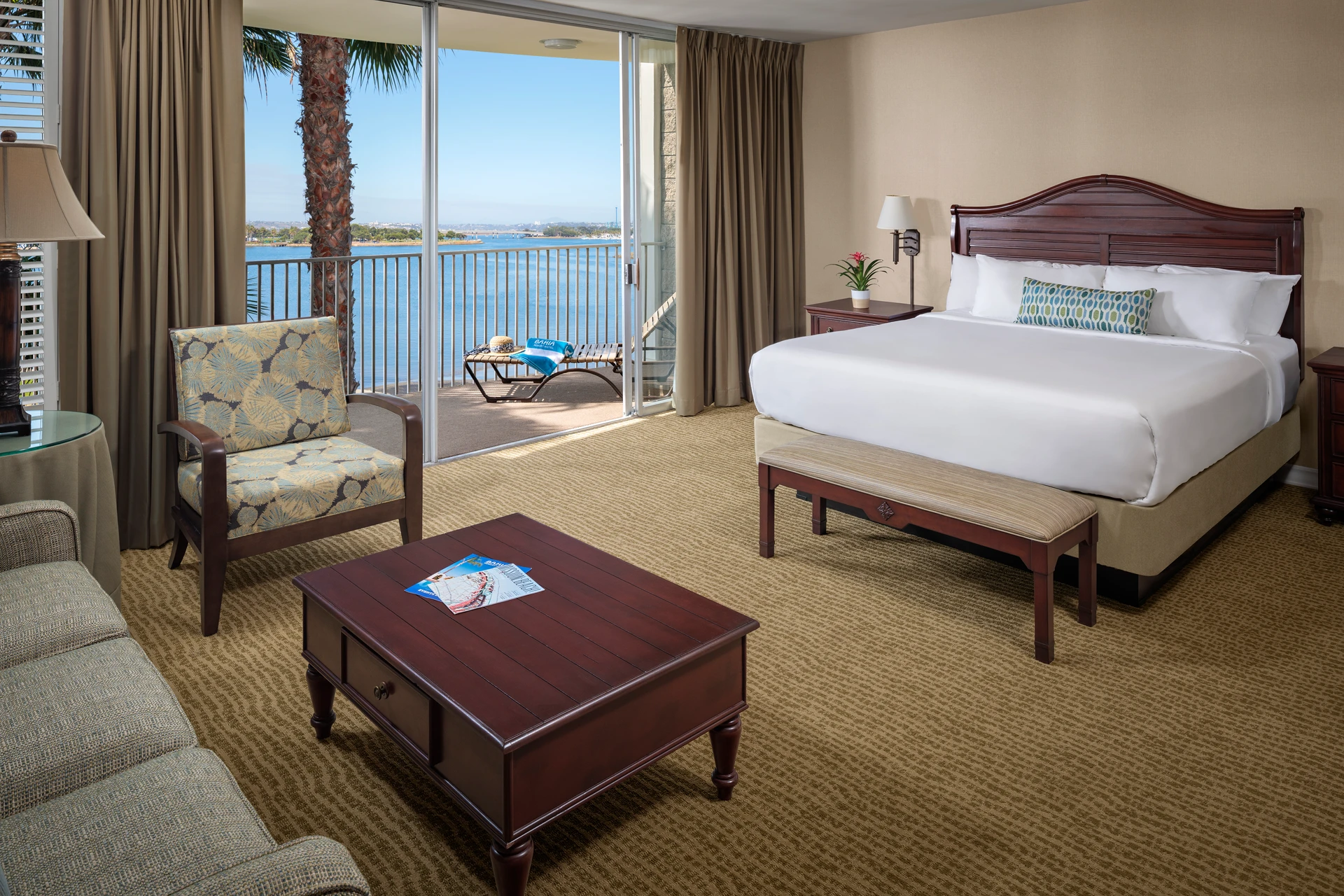 Interior of hotel room showing a bed and patio facing the bay