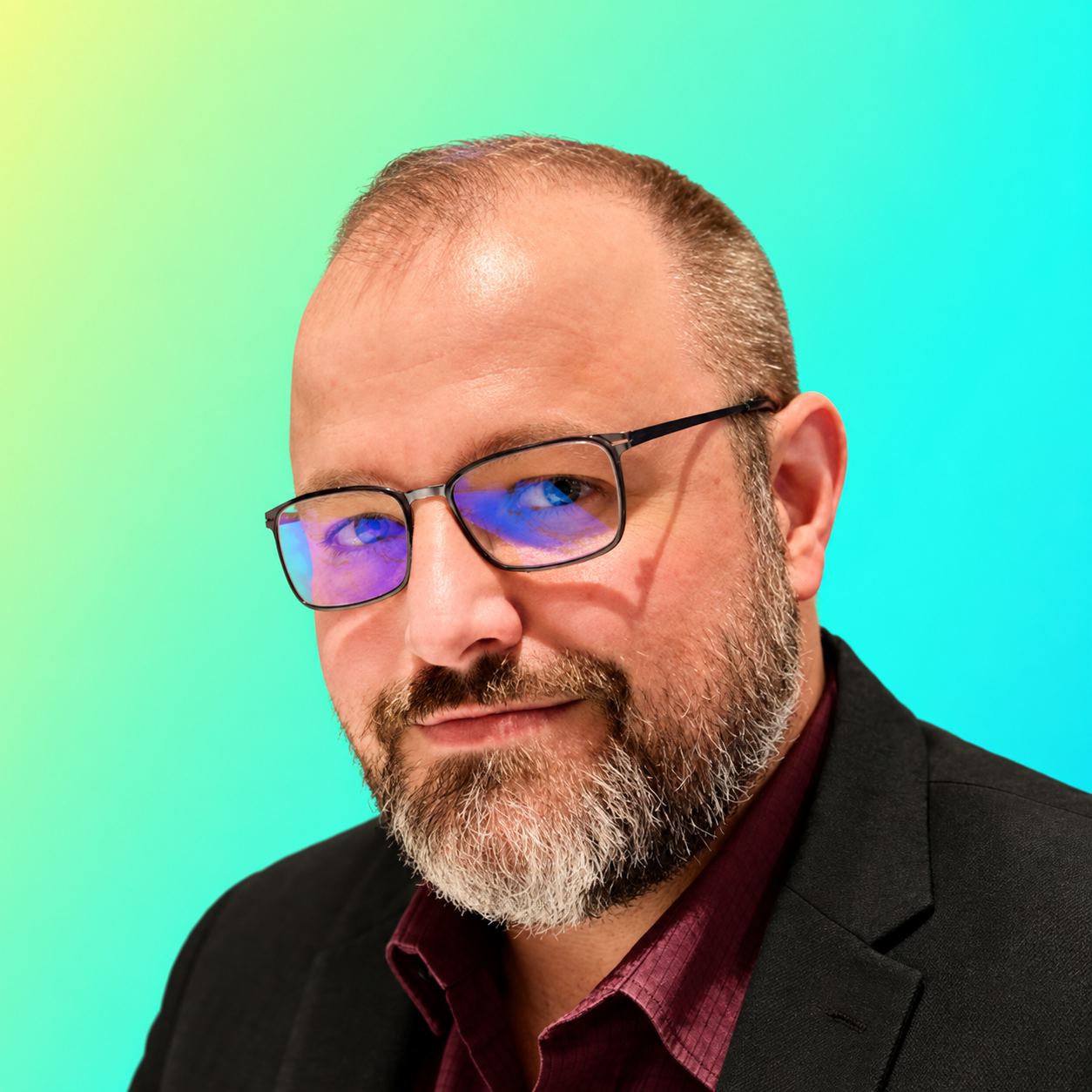 Middle-aged man with a beard and blue shirt smiling against a gradient turquoise background.