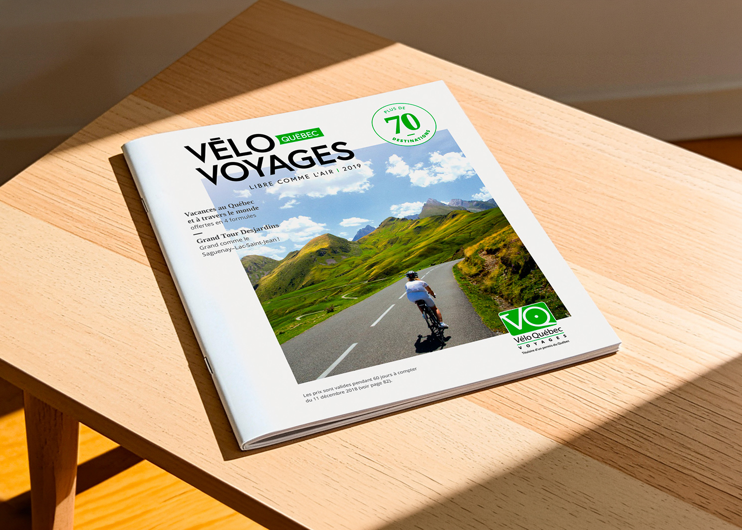 Brochure Vélo Voyages ouverte sur une table de bois
