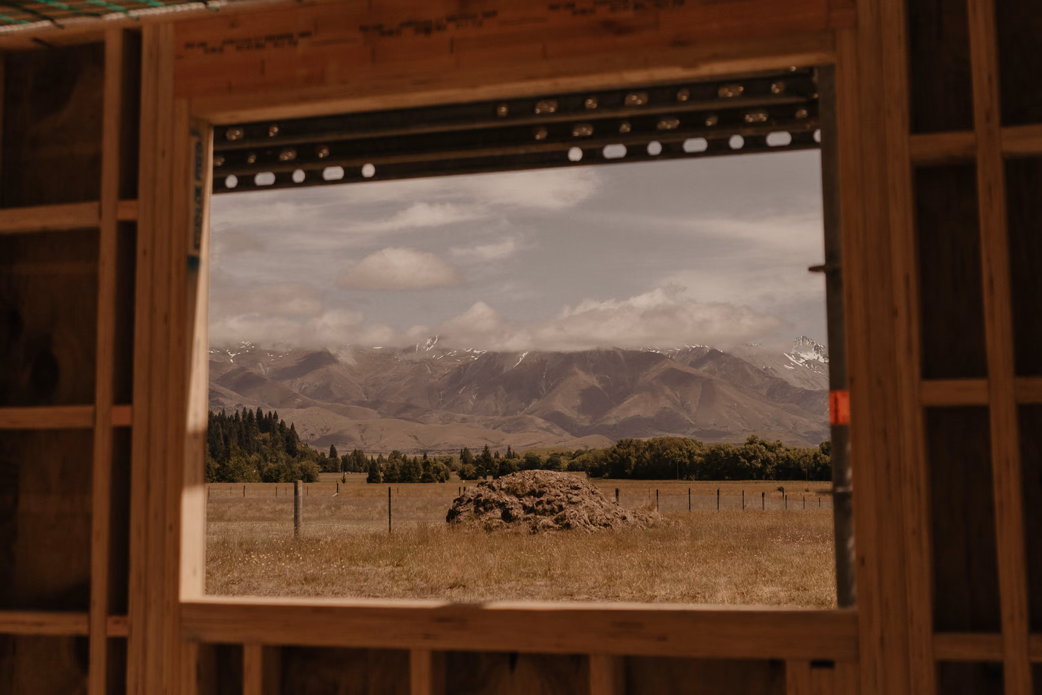 views of the mountains from an unfinished window in Twizel