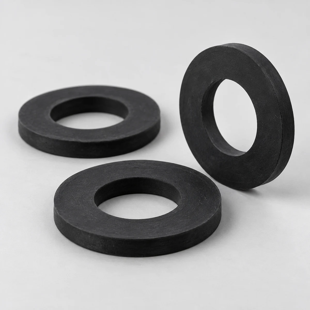 Rubber Washer - Black rubber, plain finish, circular washers with central bores (product illustration)