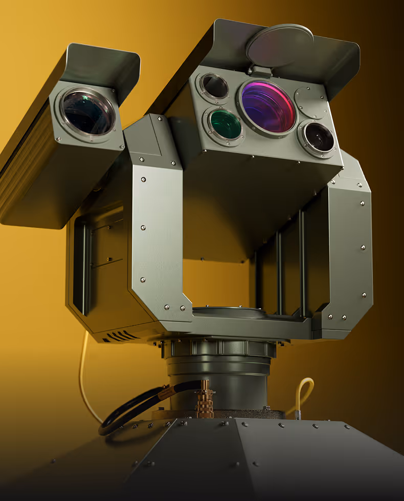 Close-up of an industrial surveillance or sensor device with multiple lenses and metal housing.