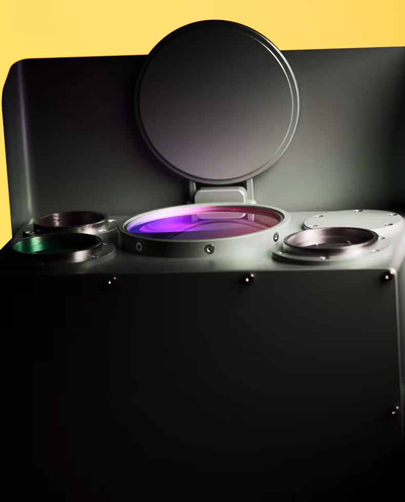 Close-up of a black high-tech device with circular lenses or sensors and a dark round cover open.