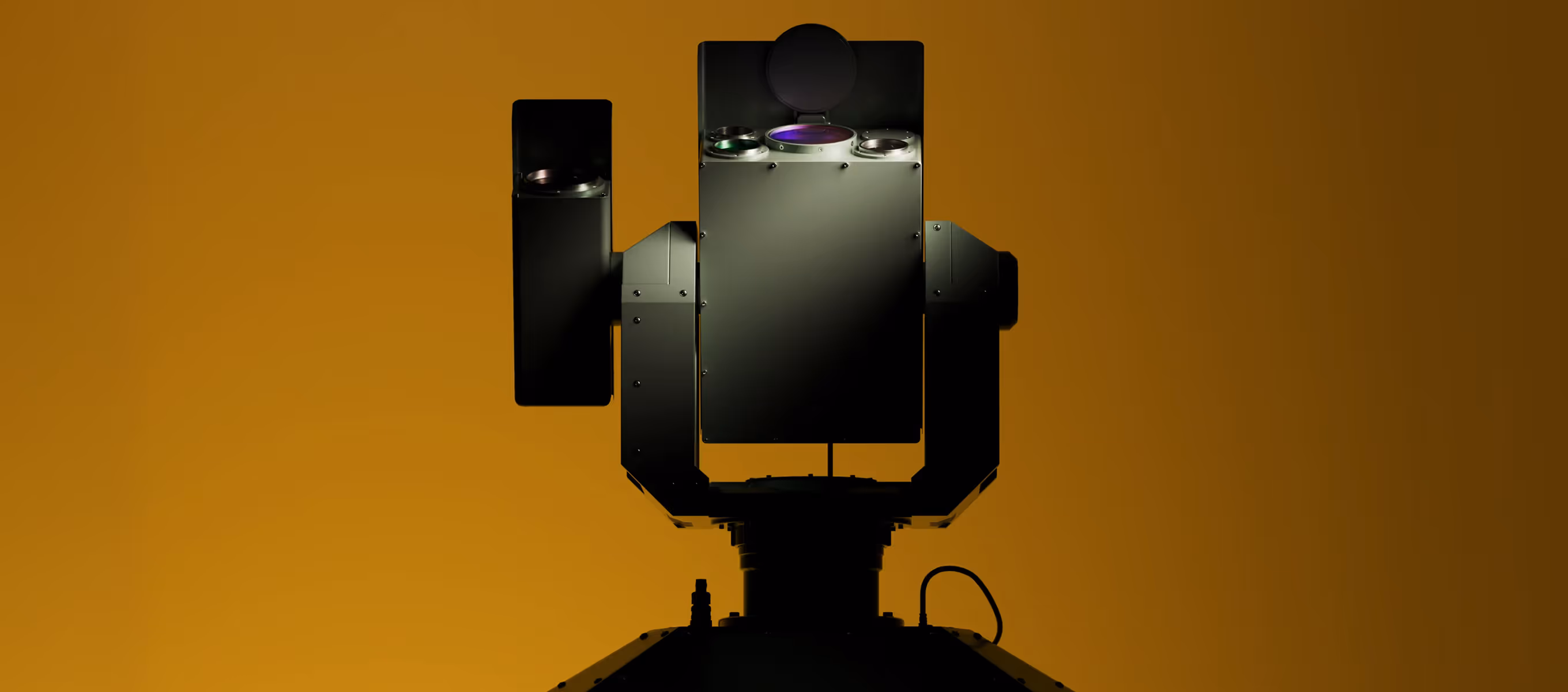Black robotic device with multiple lenses and a cable against an orange background.