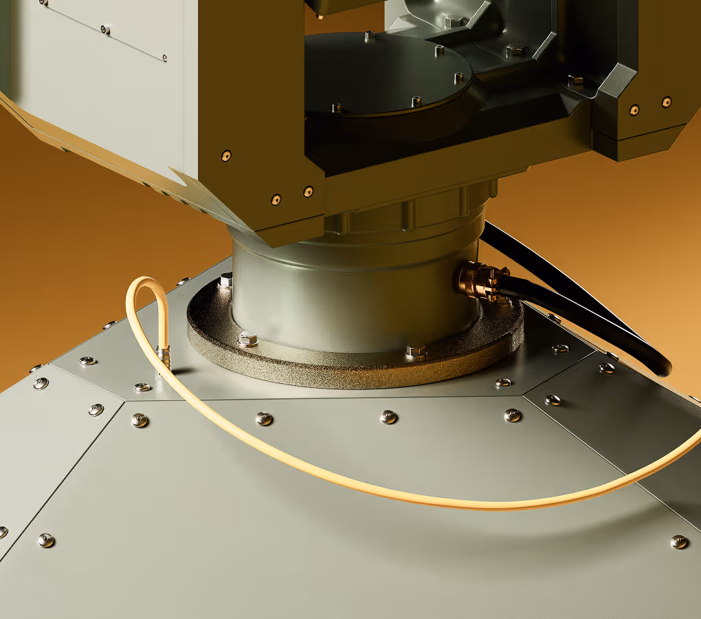 Close-up of a metal mechanical device with screws, a black cable, and a yellow looped wire.