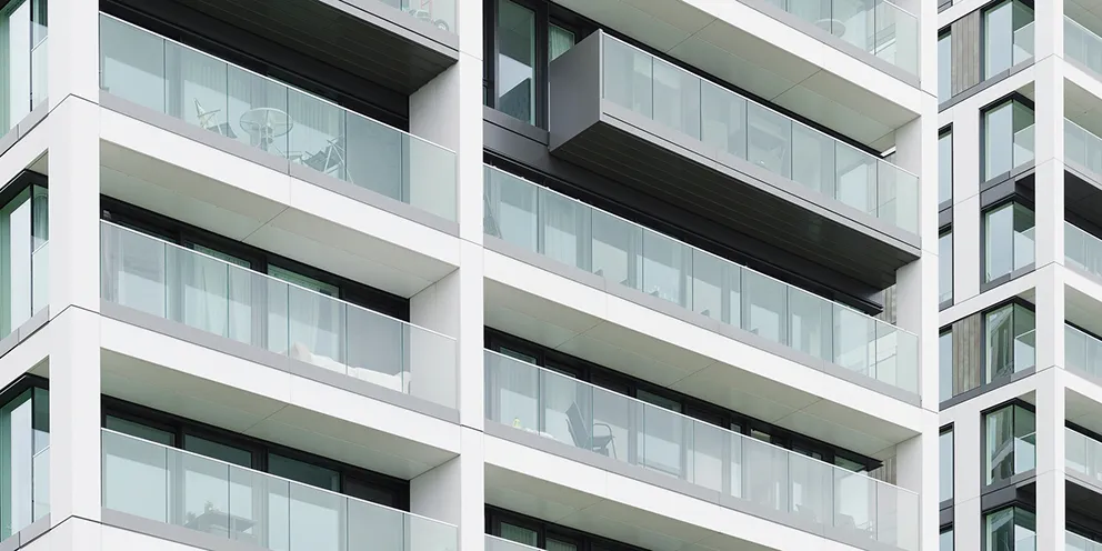 Detail moderní fasády bytového domu s prosklenými balkony