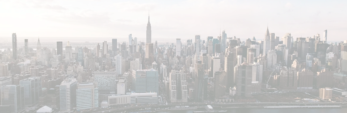 Panoramic view of New York City skyline with prominent skyscrapers including the Empire State Building at sunset.