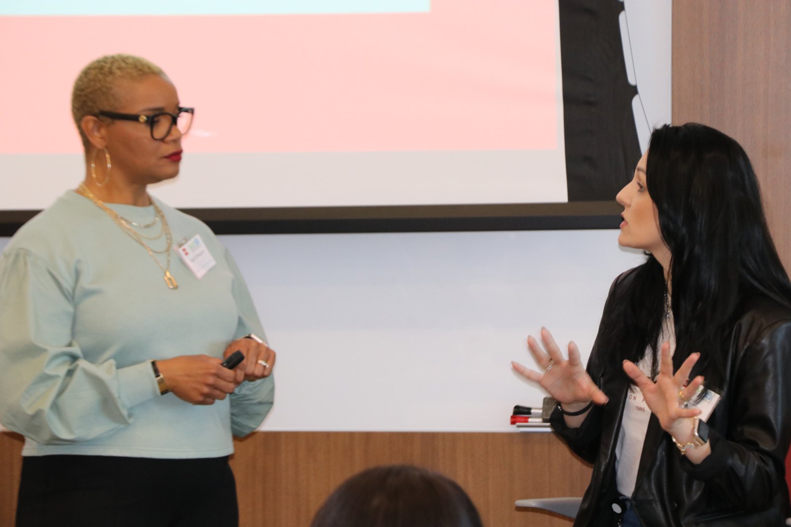 Woman presenting into microphone at SMPHR event with attentive audience