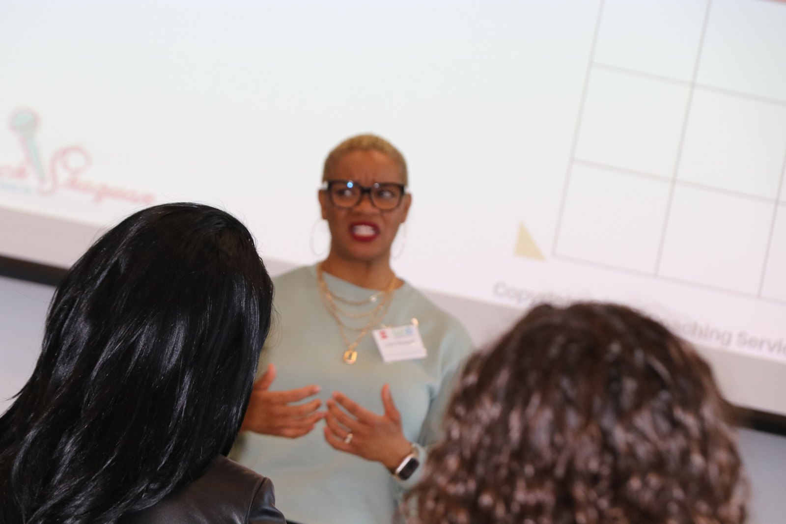 Woman speaker engaging with two attendees at close range during workshop