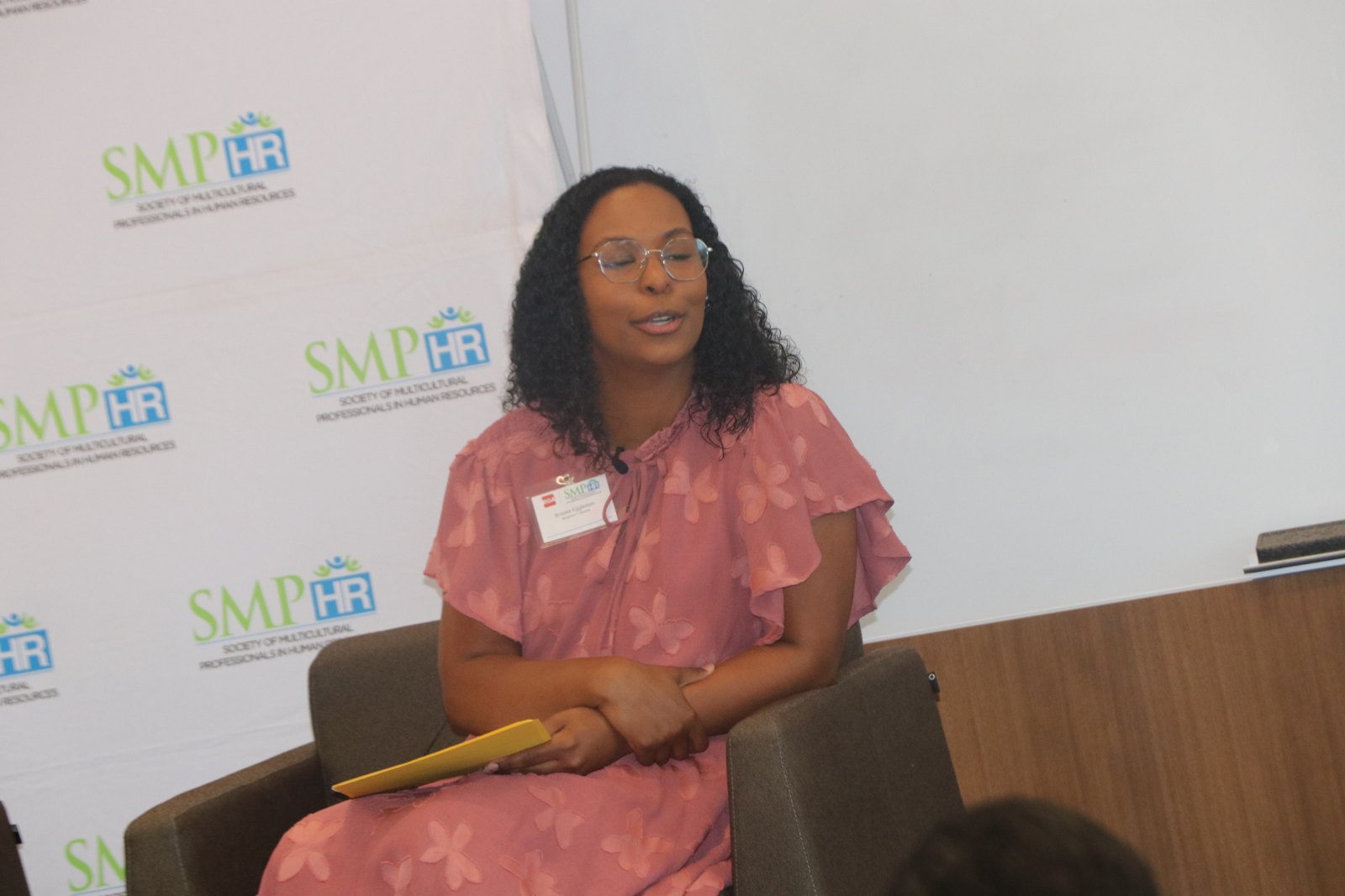 Woman speaker wearing pink top at SMPHR panel event