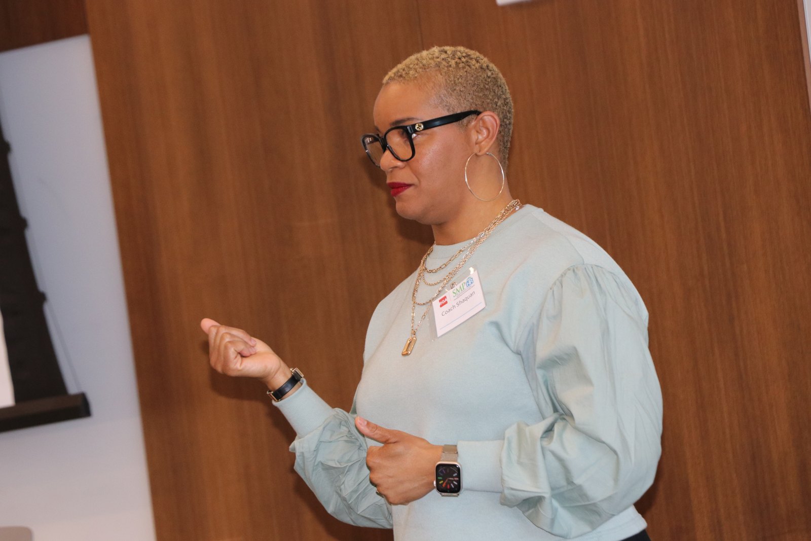 Woman speaker gesturing during remarks at SMPHR event