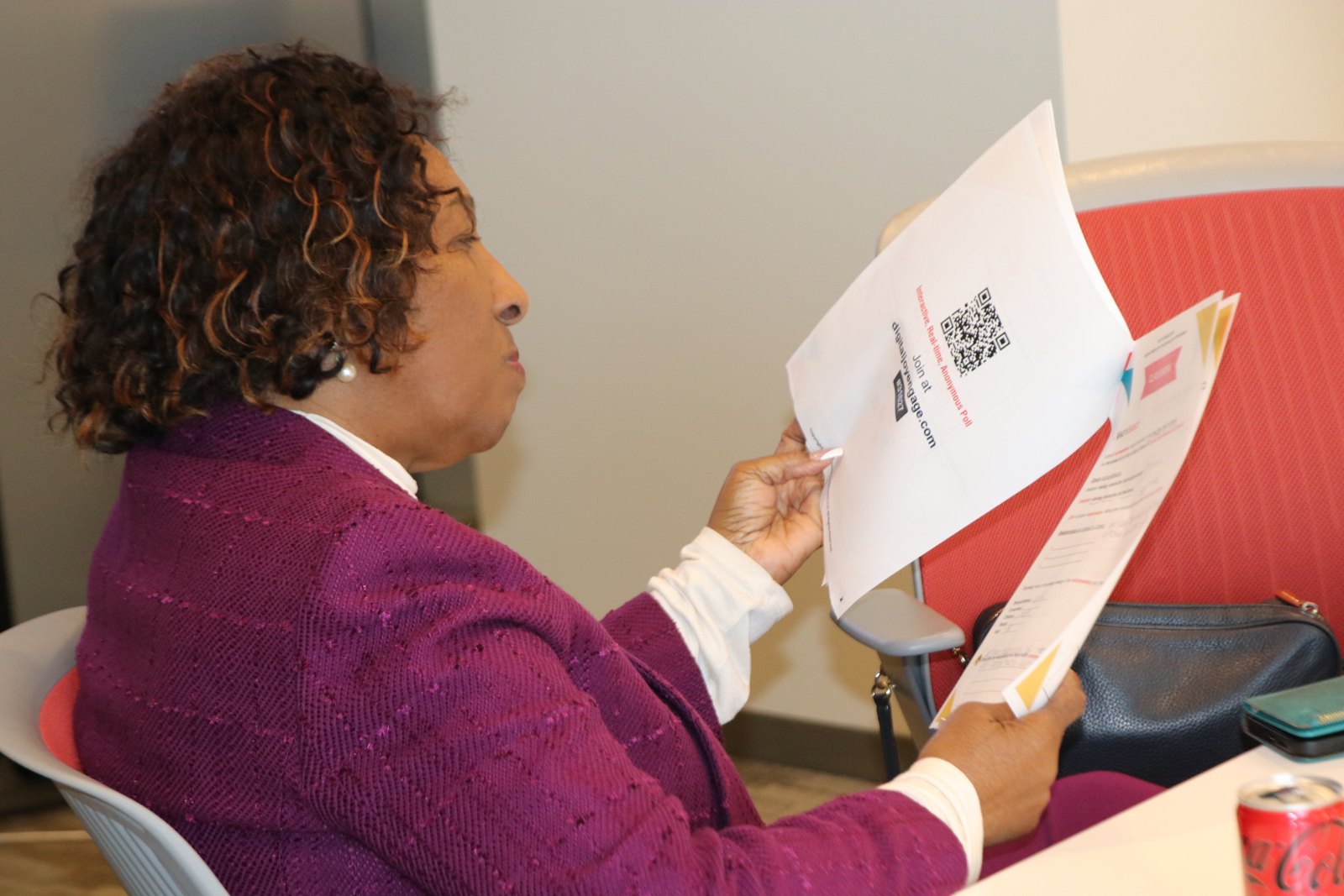 Woman reading document with QR code at workshop table