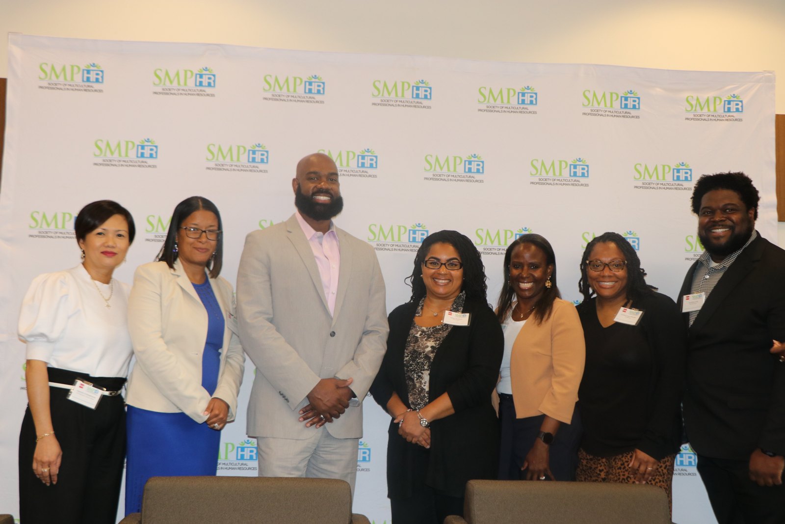 Seven professionals posing for formal photo at SMPHR event