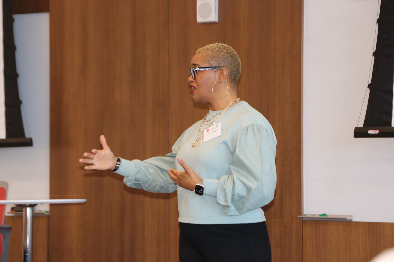 Woman speaking with expressive hand gestures at professional event