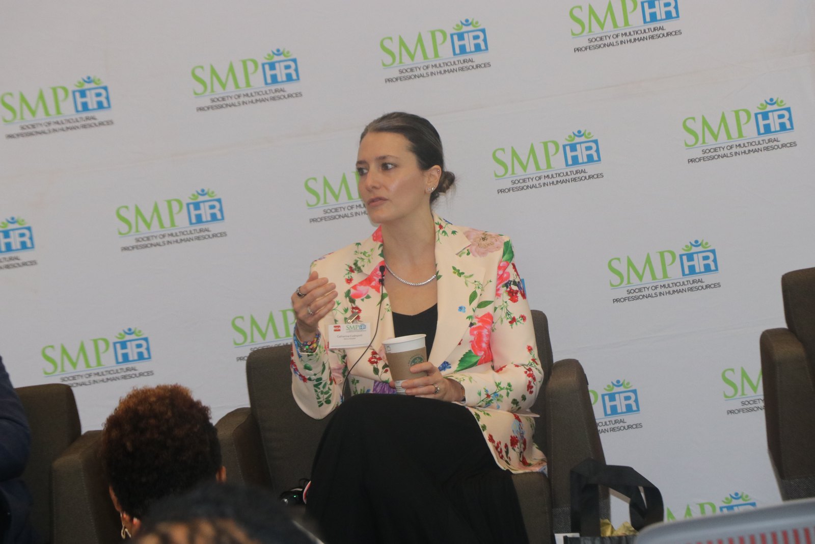 Woman in floral blazer speaking at SMPHR panel discussion