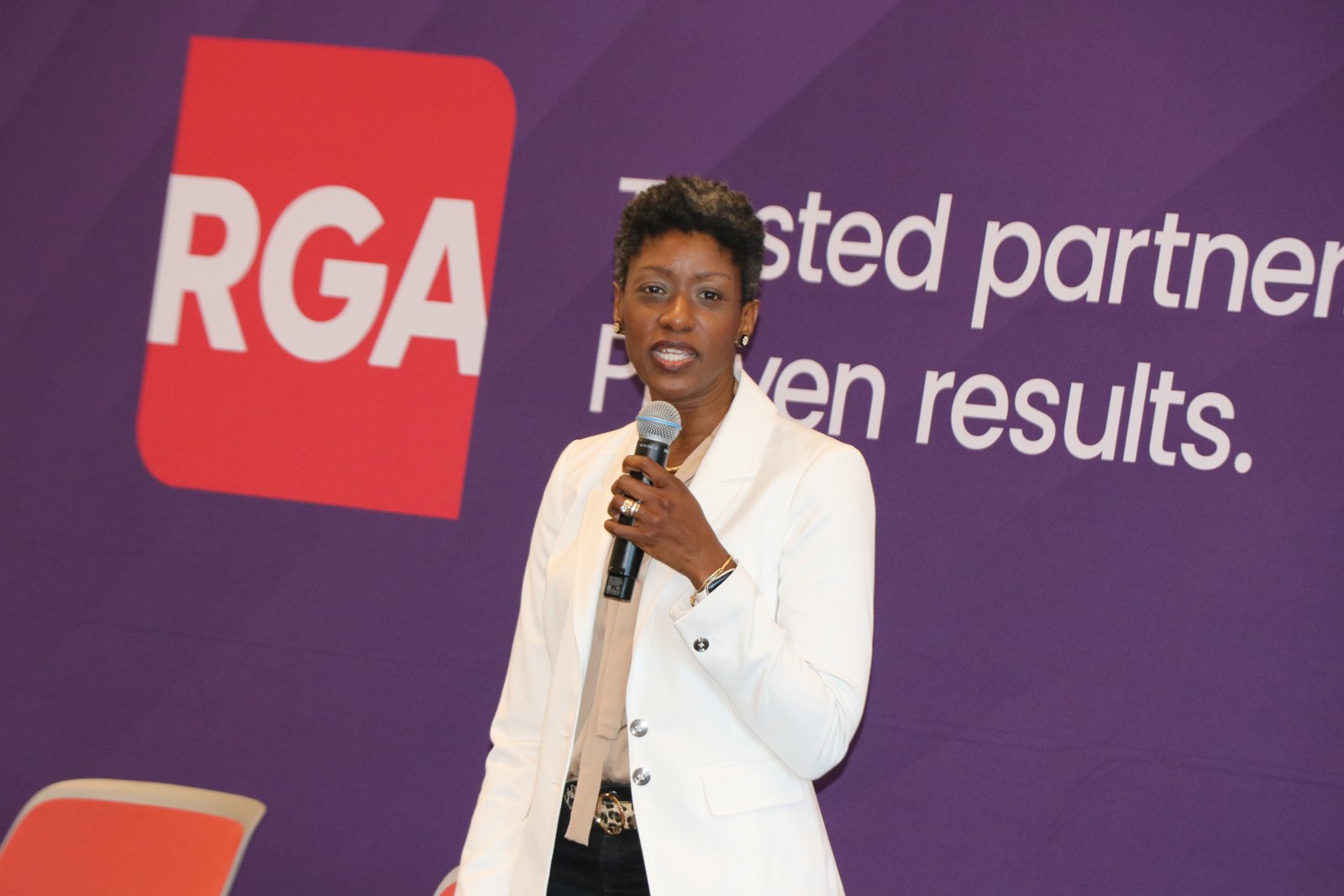Woman speaker with microphone at RGA-branded event