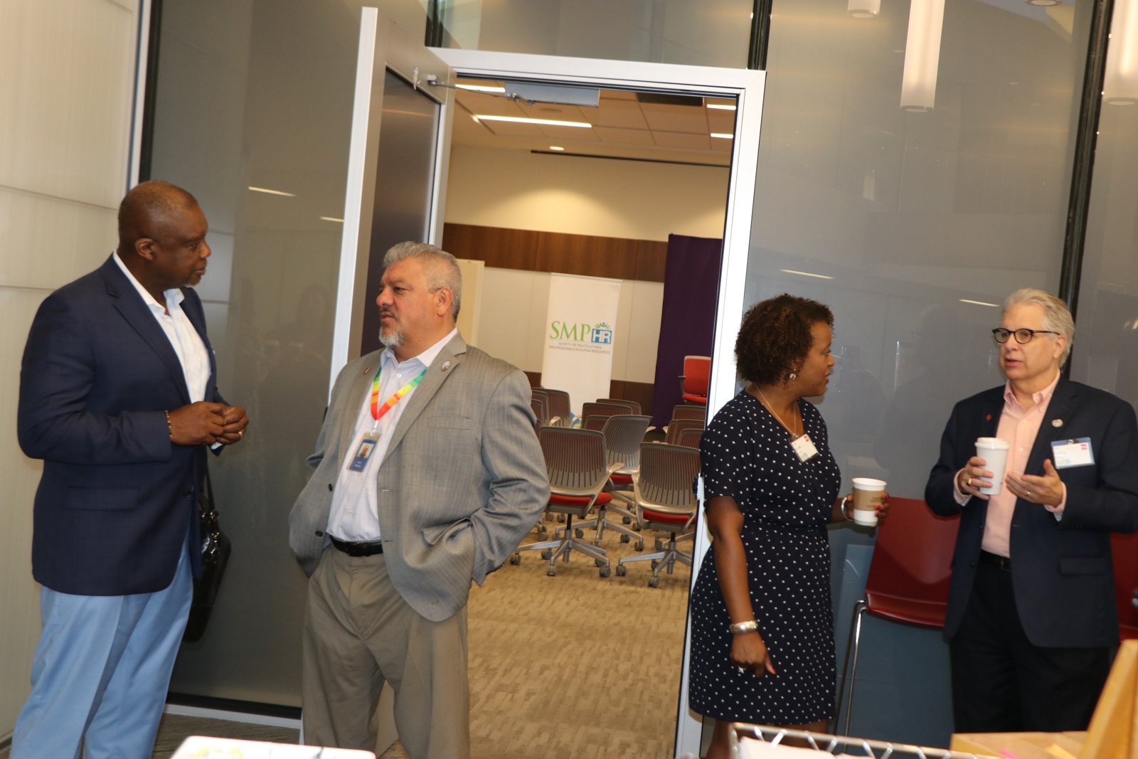 Four professionals conversing at SMPHR event