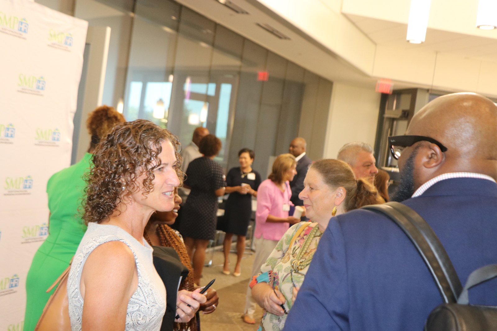 Woman in professional dress conversing at SMPHR networking event