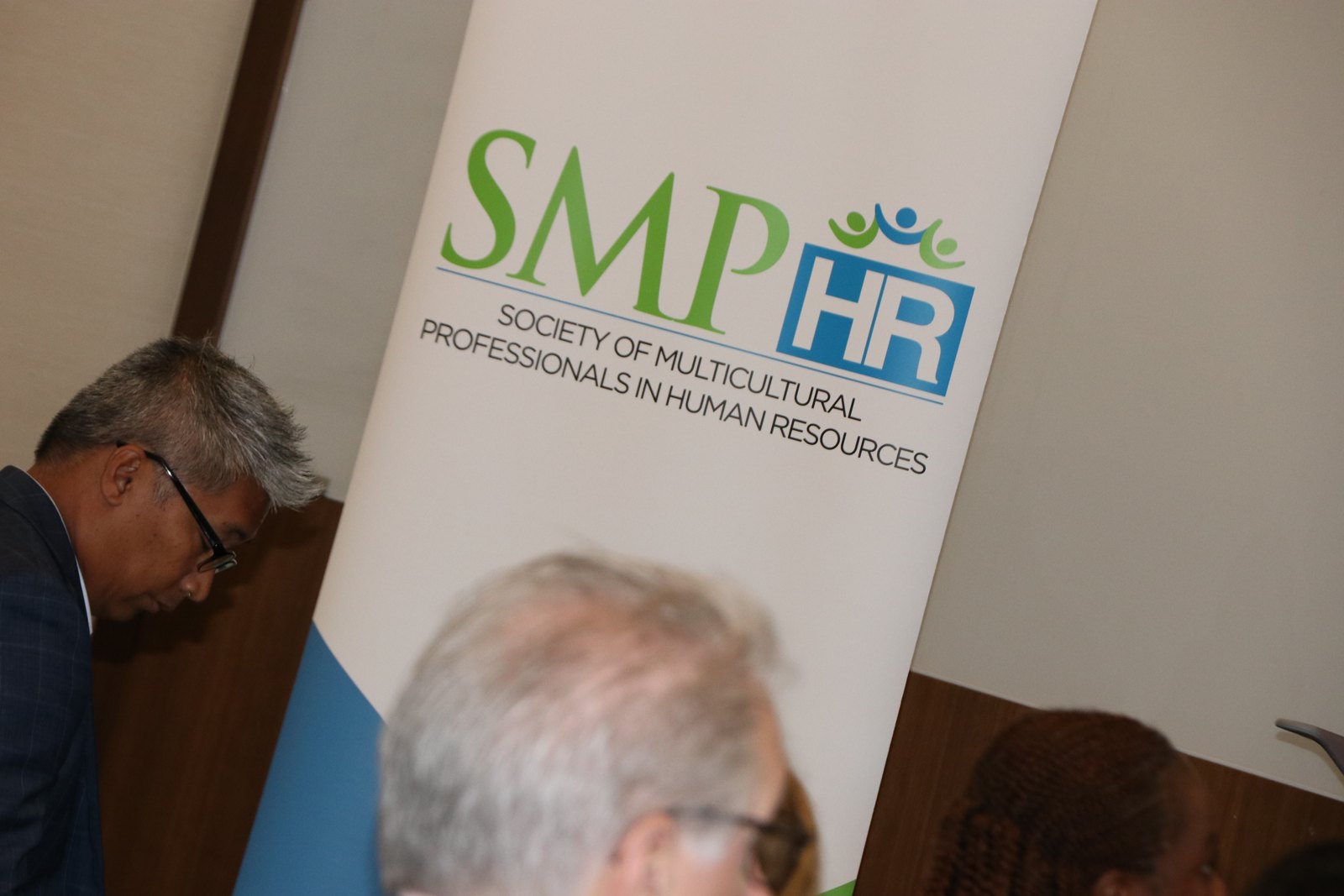 SMPHR members networking near organizational banner