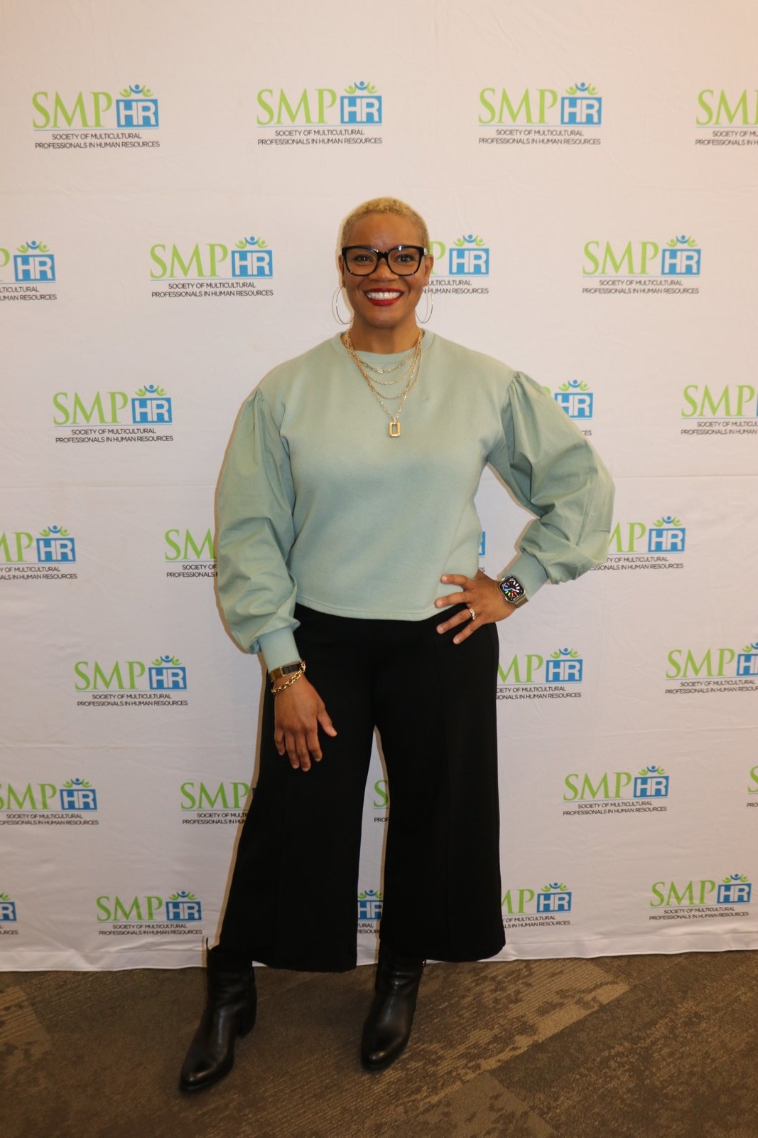 Professional with name badge at SMPHR event backdrop