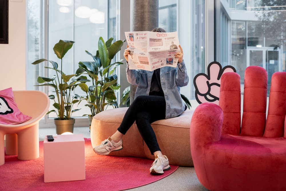Une collaboratrice lit le journal de QoQa dans les bureaux