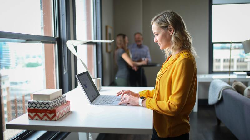 Femme qui travaille dans un espace de travail avec un bureau debout 
