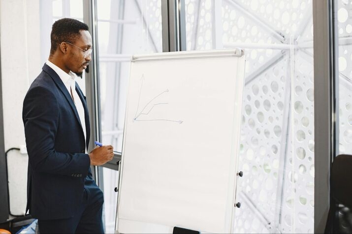 Une personne qui écrit au tableau blanc lors d’un programme de formation