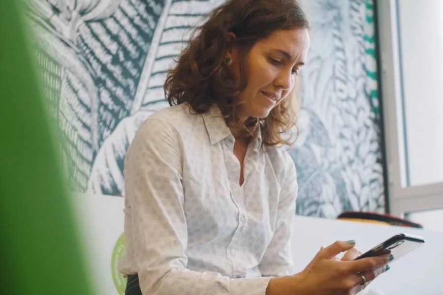 Une collaboratrice de Solimut Mutuelle consulte la plateforme sur son téléphone, dans les bureaux de la mutuelle